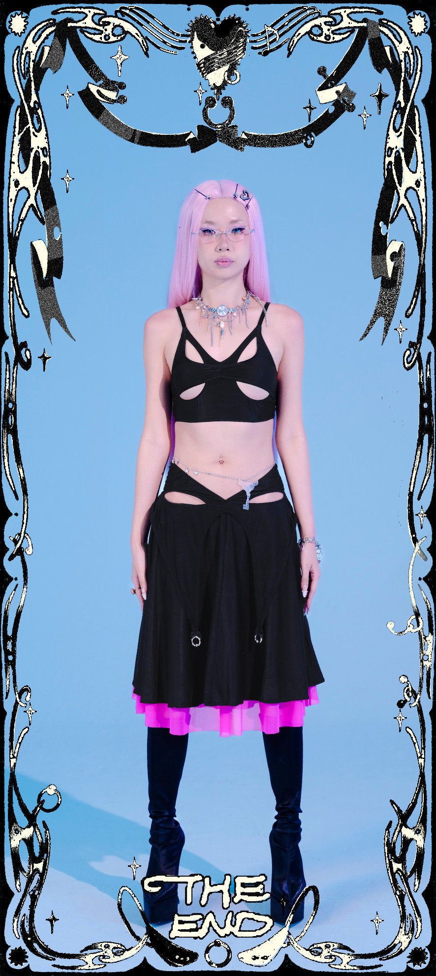 Person wearing a black outfit with pink accents against a blue background, framed by decorative elements.