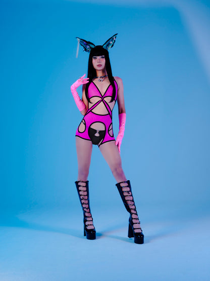 Model wearing a pink and black outfit with cat-like design on a blue background