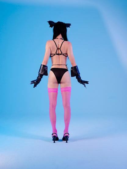 Person wearing a black strappy outfit with pink stockings on a blue background